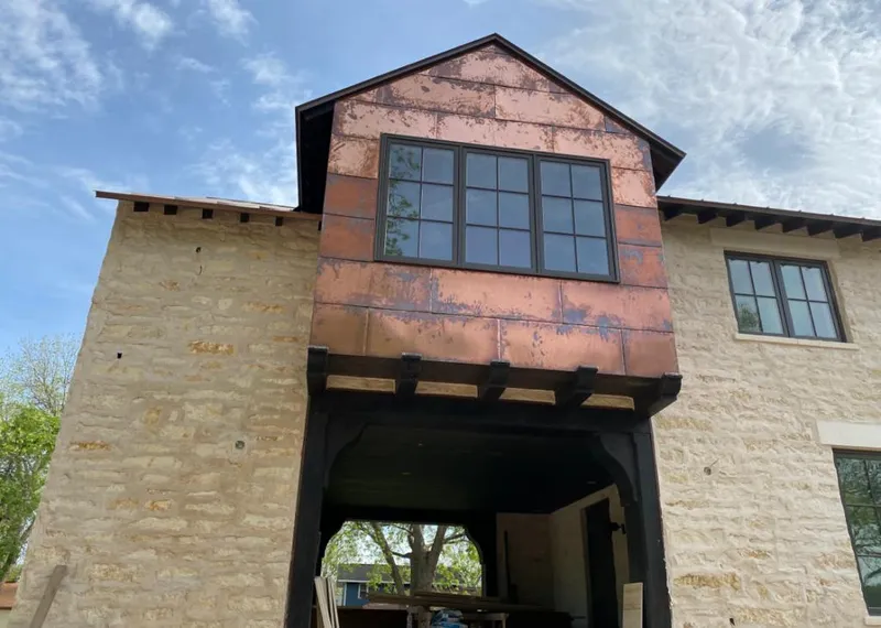 Copper metal panel facade on a stone building for Skylight Installation in Owatonna